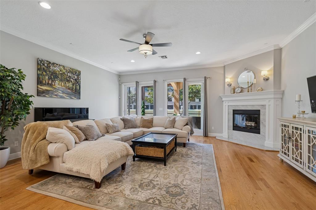 A living room features a sectional sofa, a fireplace, and hardwood floors — 610 SAXONY BOULEVARD, ST PETERSBURG, FL