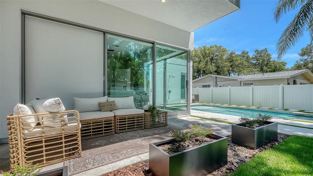 A modern two-story house features a white stucco facade, wood-paneled garage, and rectangular planters — 2010 HYDE PARK CIRCLE, SARASOTA, FL