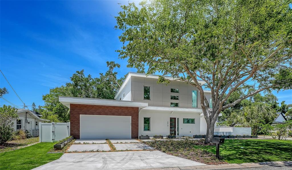 A modern two-story house with a flat roof, white exterior, and a concrete driveway — 2010 HYDE PARK CIRCLE, SARASOTA, FL