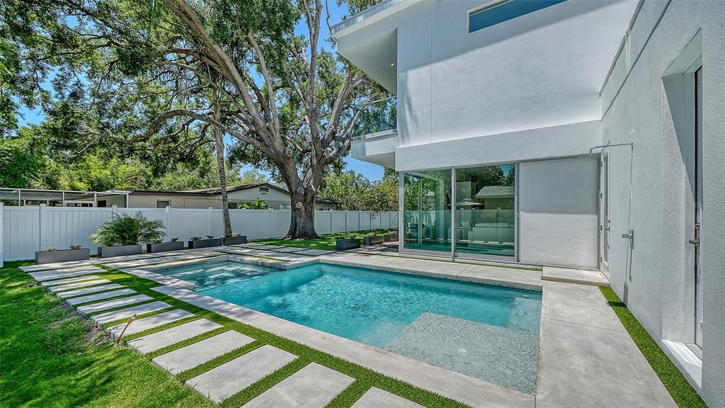 A modern two-story house with a white garage, wood-paneled accent wall, and a large tree — 2010 HYDE PARK CIRCLE, SARASOTA, FL