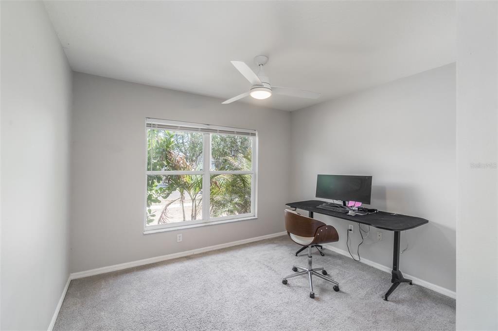 A home office features gray walls, carpeted flooring, a ceiling fan, and a desk setup — 1707 BONDURANT WAY, BRANDON, FL