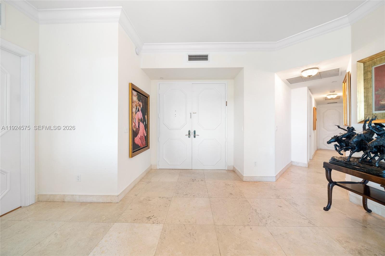 A bright entryway features white double doors, light tile flooring, and a bronze horse sculpture — 10225 Collins Ave # 404, Bal Harbour FL 33154, BAL HARBOUR, FL