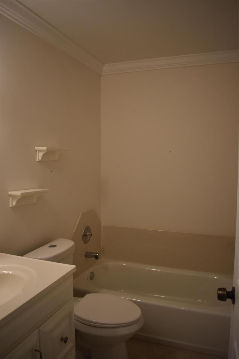 A bathroom features a white vanity, toilet, and a bathtub with a beige tile surround — 3374 Perimeter Drive, FL 33467, FL