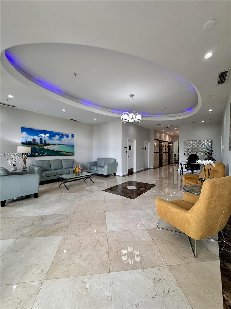 A spacious lobby features marble floors, a recessed oval ceiling with blue lighting, and seating areas — 2301 SW 27th Ave # 1500, Miami FL 33145, MIAMI, FL