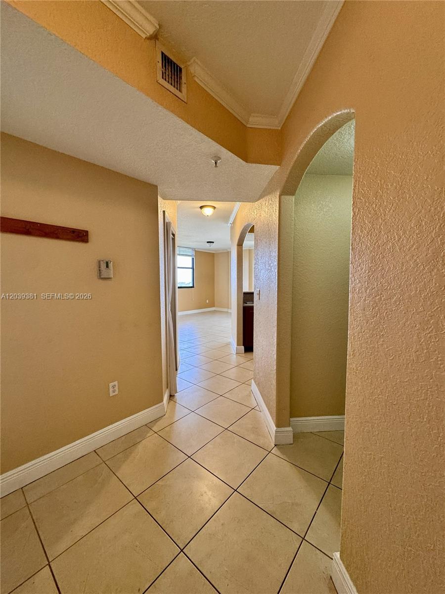 A tiled hallway leads toward a living area with an arched entryway on the right — 2301 SW 27th Ave # 1500, Miami FL 33145, MIAMI, FL
