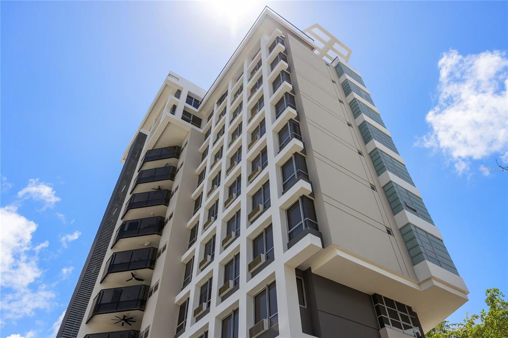 A low-angle view of a modern high-rise apartment building with balconies and glass windows — 1212 LUCHETTI ST UNIT PH, SAN JUAN, PR