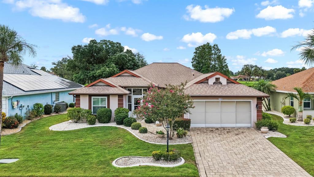 A single-story house with a tan roof, beige stucco walls, and a paved driveway — 739 WINTERBROOKE WAY, SUN CITY CENTER, FL
