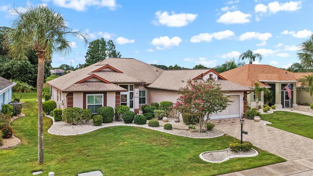 A single-story suburban house with a tan stucco exterior, a shingled roof, and a landscaped yard — 739 WINTERBROOKE WAY, SUN CITY CENTER, FL