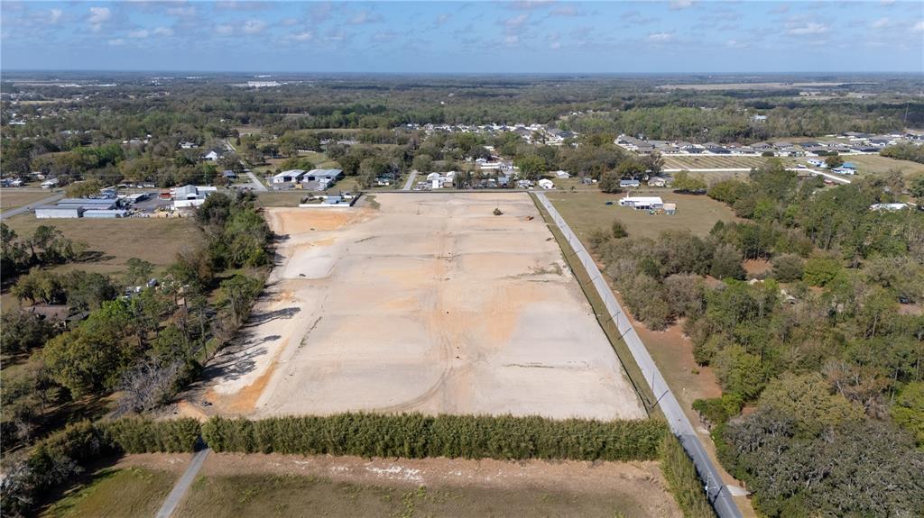 An aerial view shows a large, cleared rectangular plot of land bordered by trees — 12919 POMPANIC STREET, SAN ANTONIO, FL