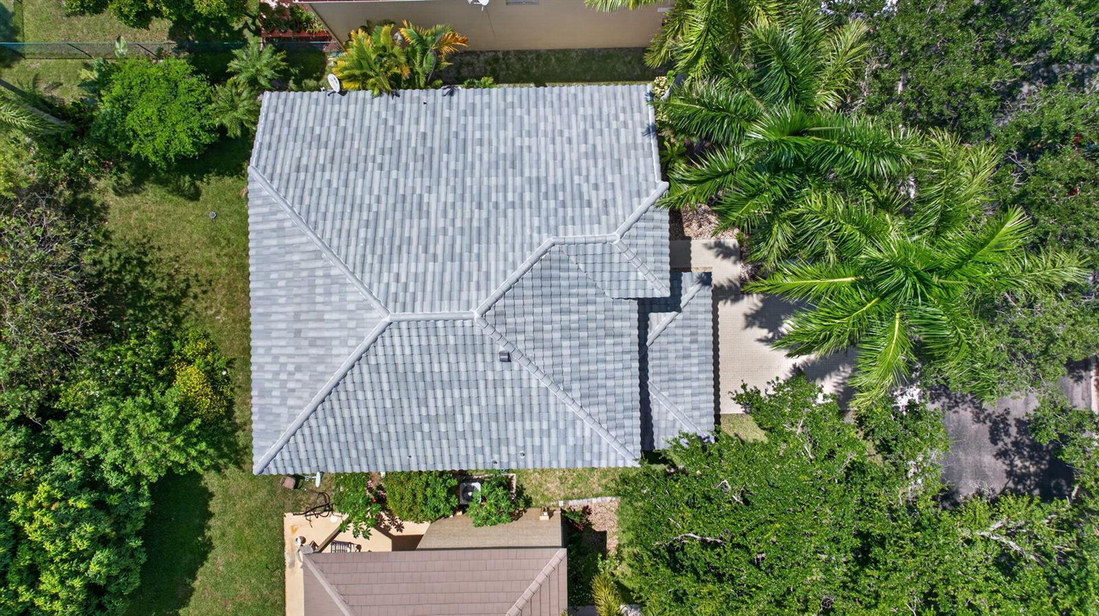 An aerial view shows a gray tiled hip roof on a house surrounded by trees — 6702 NW 80th Manor, Parkland FL 33067, PARKLAND, FL