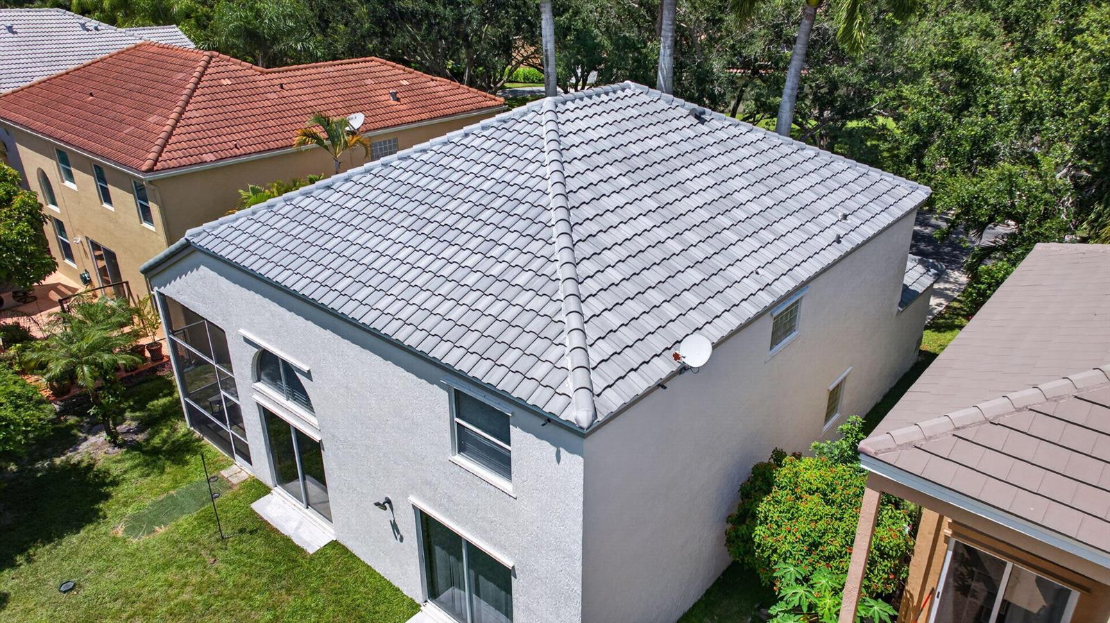 An aerial view shows the gray tiled roof and white stucco exterior of a two-story house — 6702 NW 80th Manor, Parkland FL 33067, PARKLAND, FL