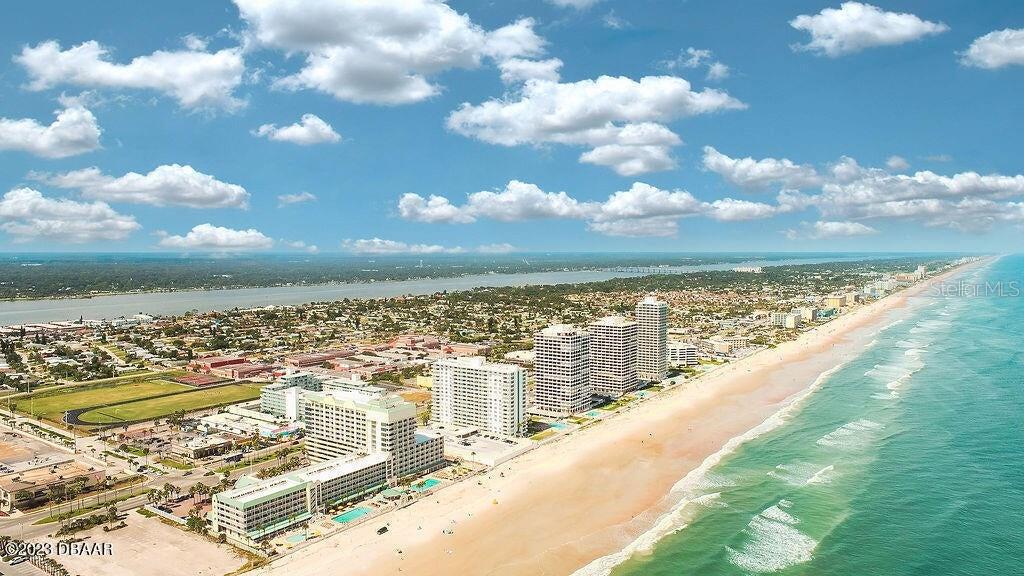 An aerial view shows high-rise buildings along a sandy beach bordering the ocean — 2700 N ATLANTIC AVENUE UNIT 342, DAYTONA BEACH, FL