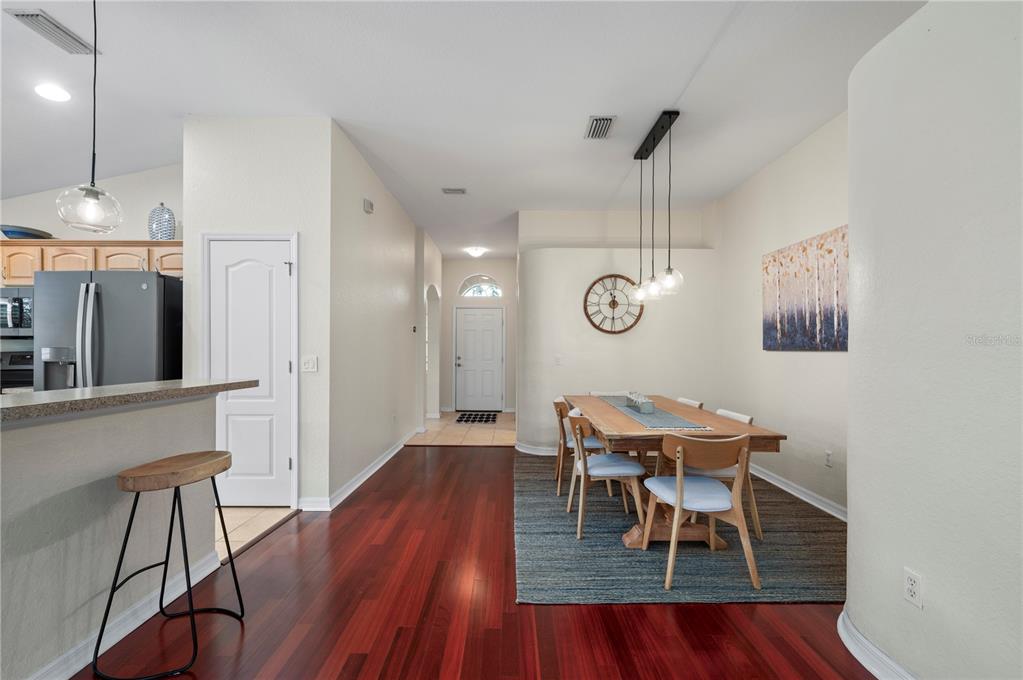 A dining area with a wooden table and chairs sits adjacent to a kitchen counter — 1611 SCARLETT AVENUE, NORTH PORT, FL