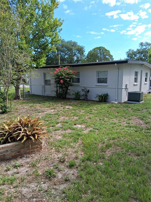 A single-story house with white stucco walls, a flat roof, and a grassy yard — 1603 SCOTT STREET, CLEARWATER, FL