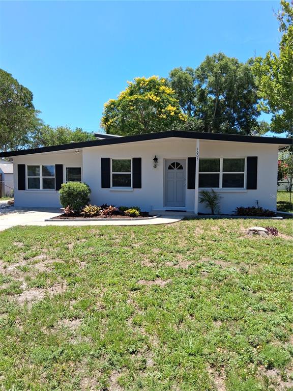 A single-story house with a white exterior, black trim, and a front yard — 1603 SCOTT STREET, CLEARWATER, FL