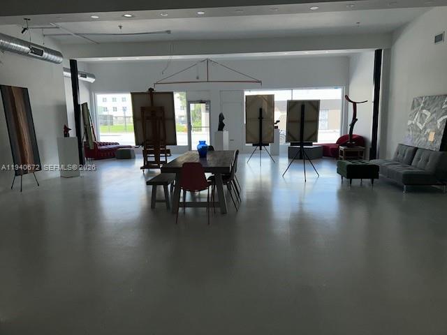 A spacious art studio features concrete floors, large windows, and several easels — 5600 NW 7 Ave, Miami FL 33127, MIAMI, FL