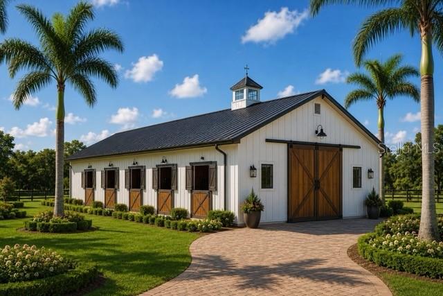 A white barn with a black metal roof and wooden sliding doors sits on a lawn — TBD HWY 329, REDDICK, FL