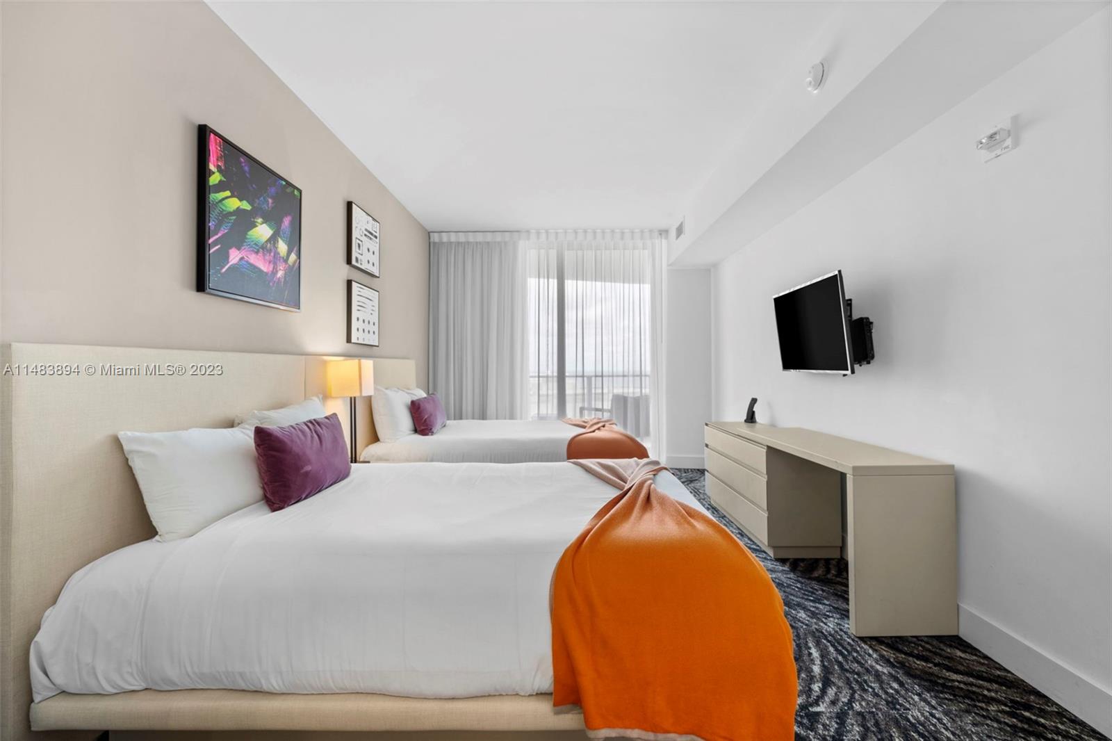 A hotel room features two beds, a wall-mounted television, and a desk — 4111 S Ocean Dr # 1406, Hollywood FL 33019, HOLLYWOOD, FL