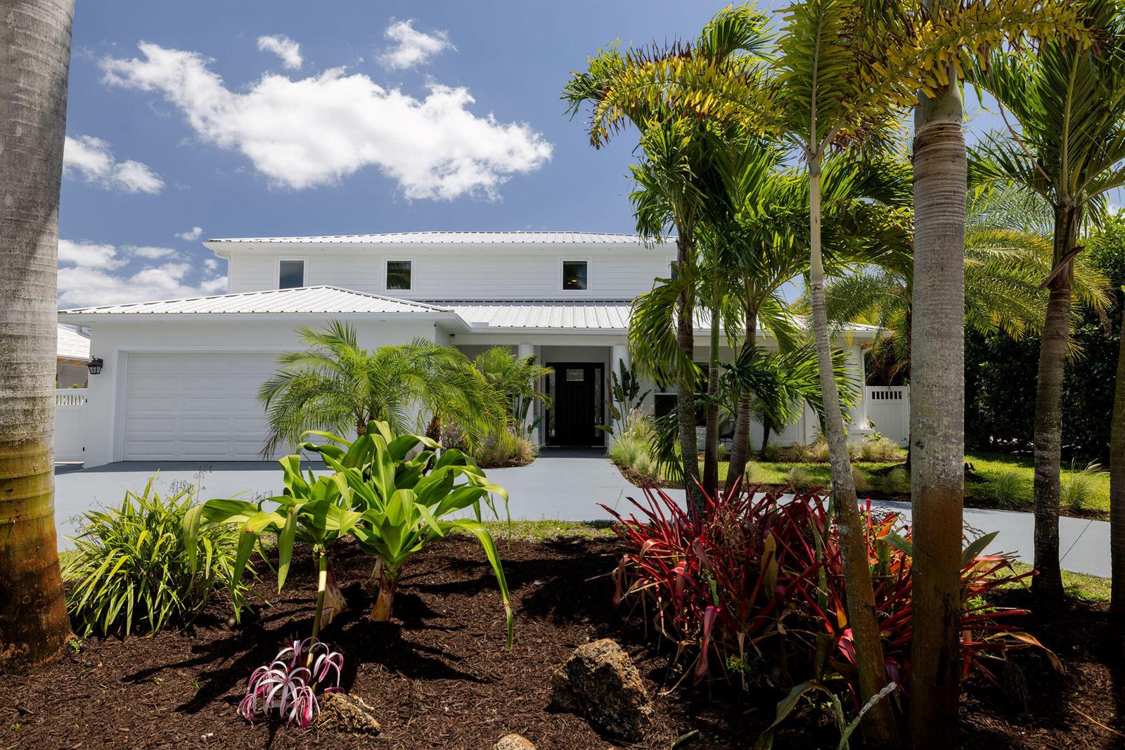A two-story white house with a metal roof and palm trees in the front yard — 19298 Gulfstream Drive, Jupiter FL 33469, JUPITER, FL
