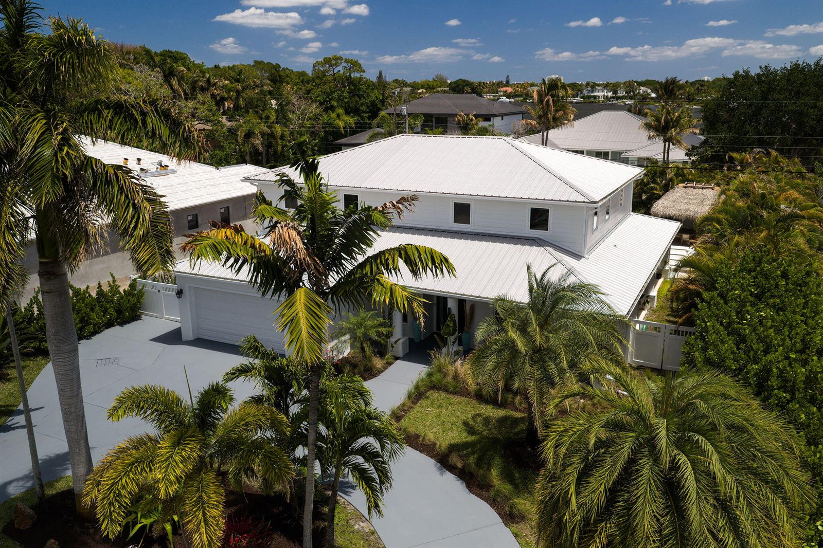 An aerial view of a white two-story house with a metal roof and palm trees — 19298 Gulfstream Drive, Jupiter FL 33469, JUPITER, FL
