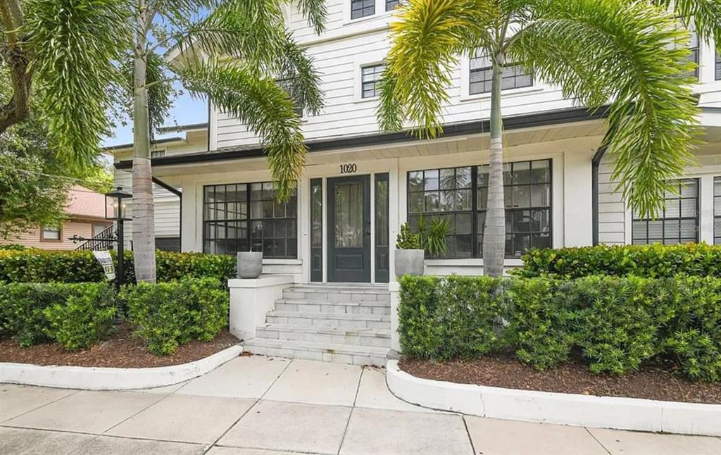 The exterior of a white multi-story house features a front porch with steps and landscaping — 1020 S ROME AVENUE UNIT 2, TAMPA, FL