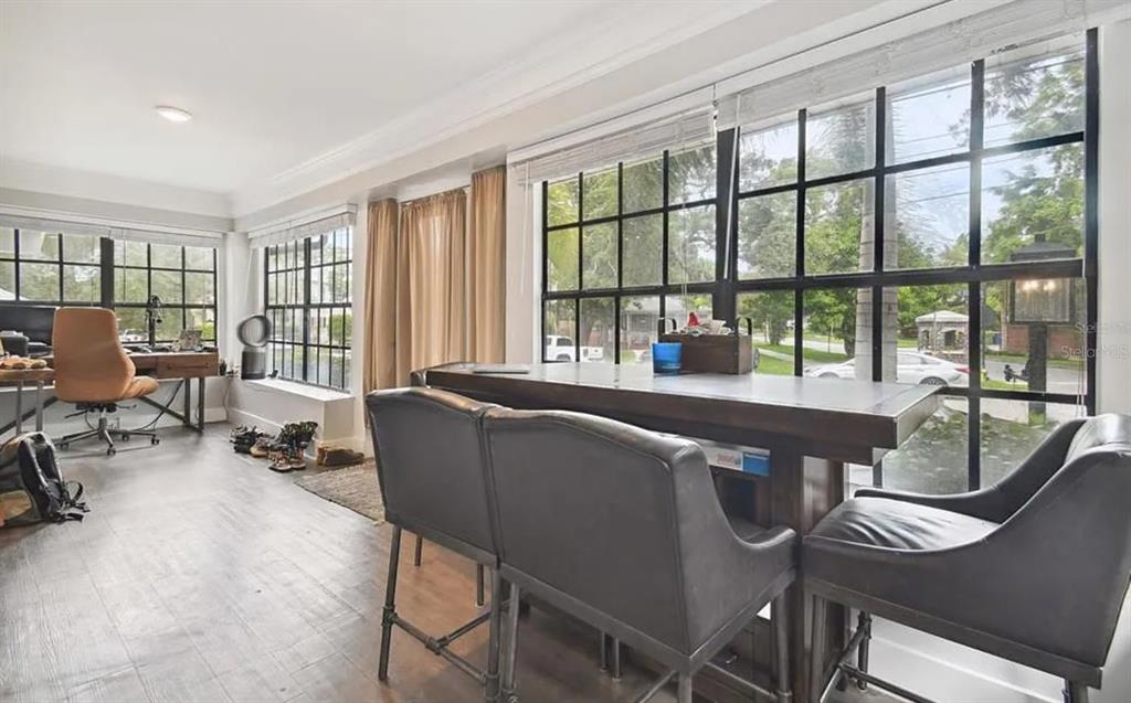 A room with dark wood flooring, large grid windows, a desk, and a high-top table — 1020 S ROME AVENUE UNIT 2, TAMPA, FL
