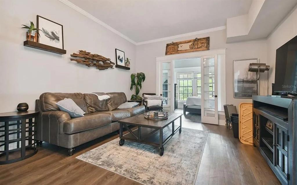 A living room features a brown leather sofa, coffee table, area rug, and French doors — 1020 S ROME AVENUE UNIT 2, TAMPA, FL