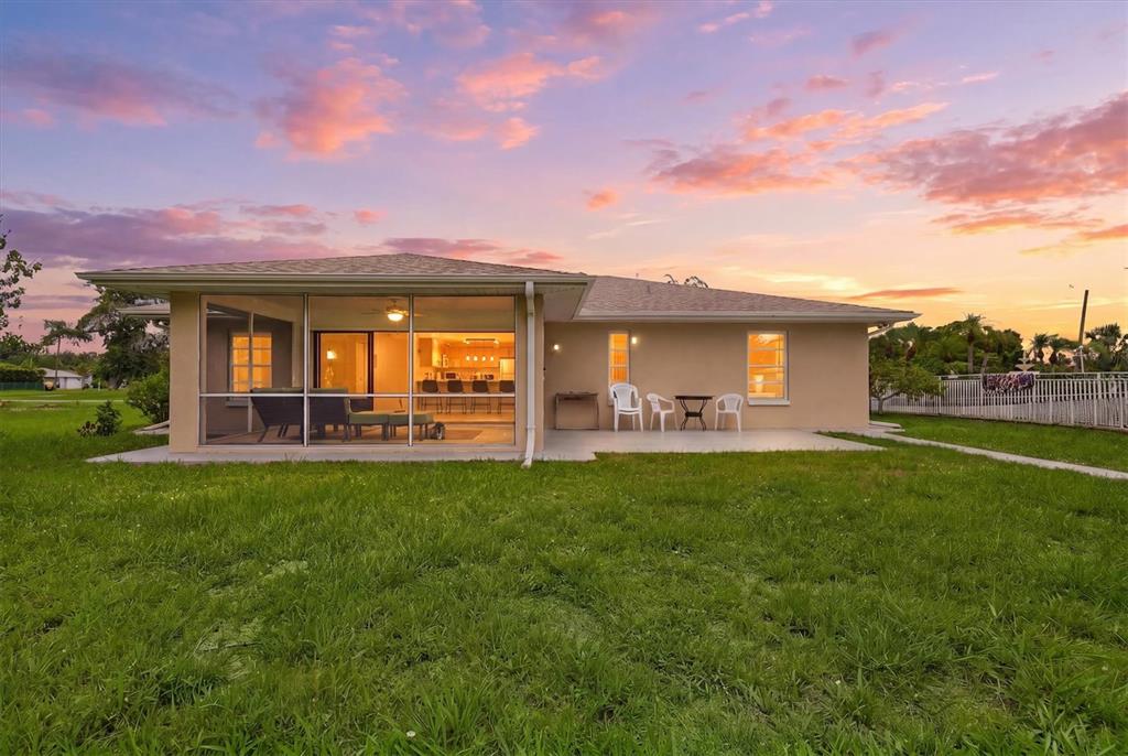 The exterior of a tan house with a screened-in patio at sunset — 320 SAN RAFAEL AVENUE, NORTH PORT, FL
