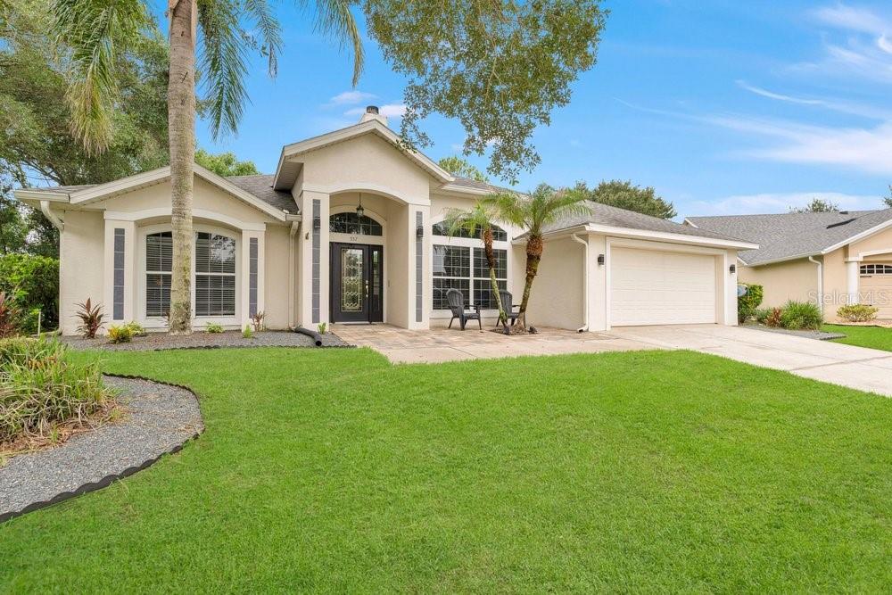 A single-story house with a beige stucco exterior, a two-car garage, and a front lawn — 557 QUAIL CREST COURT, DEBARY, FL