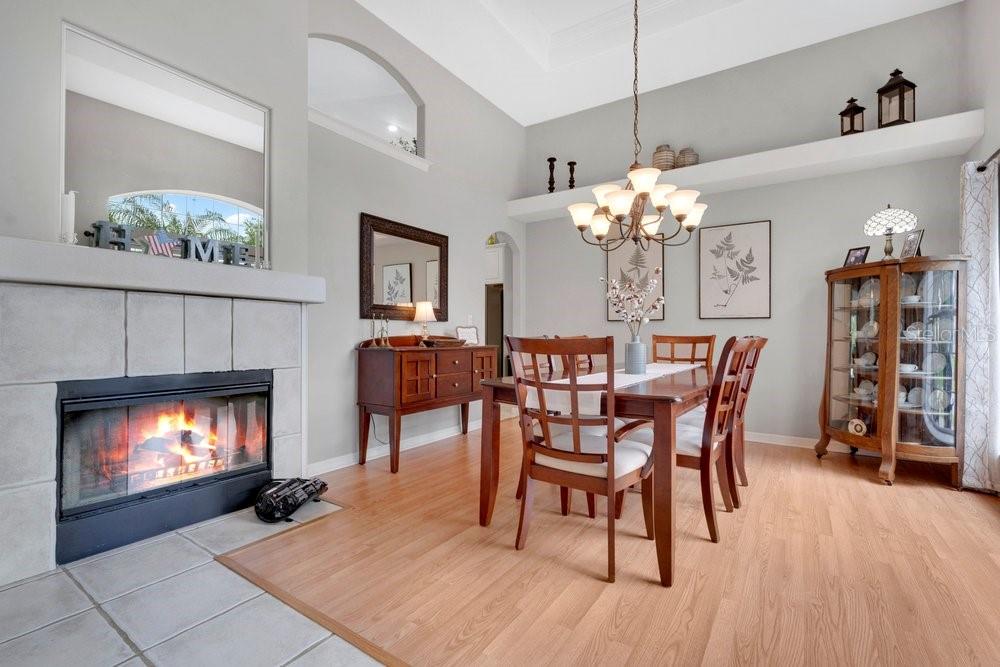 A dining room with a fireplace, wood flooring, a chandelier, and a wooden china cabinet — 557 QUAIL CREST COURT, DEBARY, FL