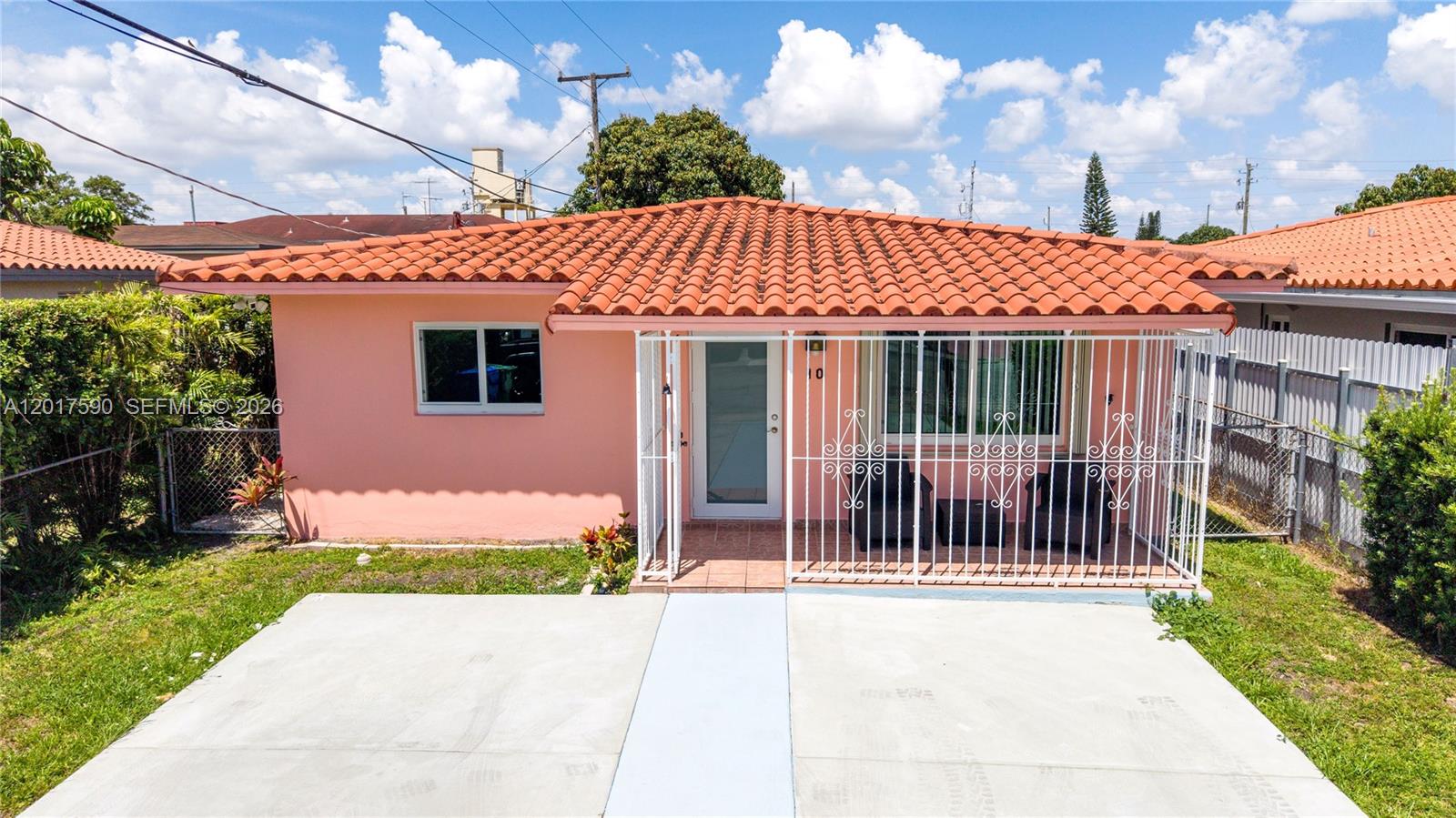 A pink single-story house features a red tile roof and a white security gate — 10 NW 60th Ct, Miami FL 33126, MIAMI, FL