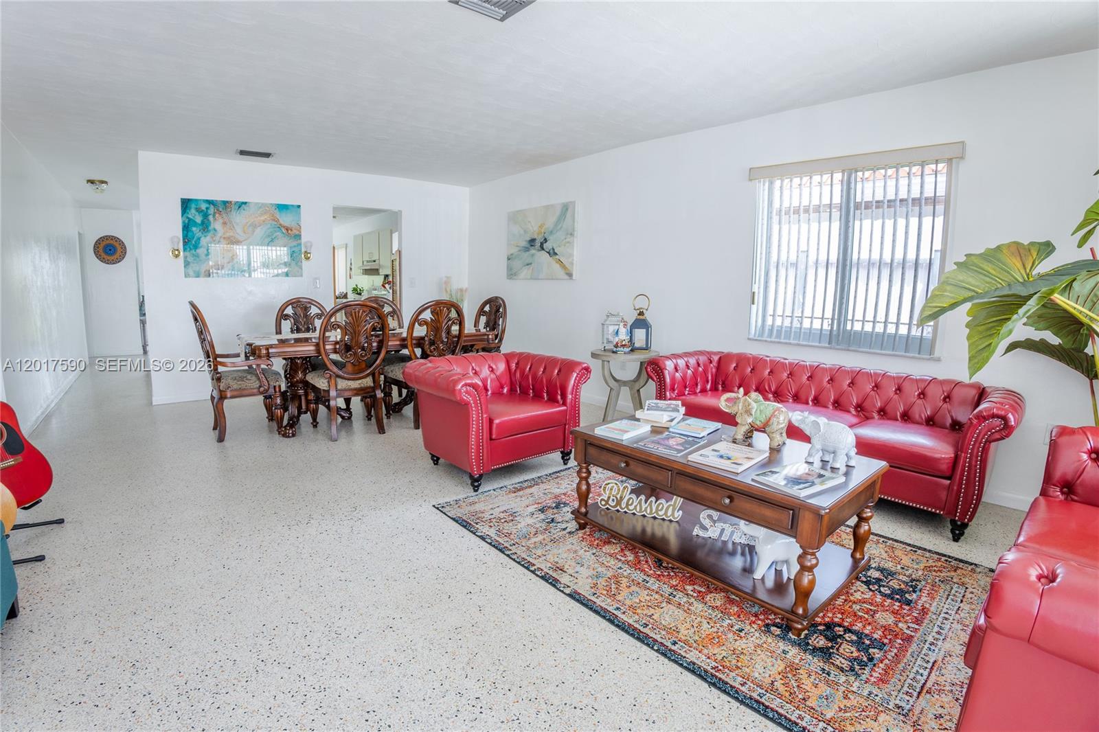 A living and dining room features red leather furniture, a patterned rug, and white walls — 10 NW 60th Ct, Miami FL 33126, MIAMI, FL