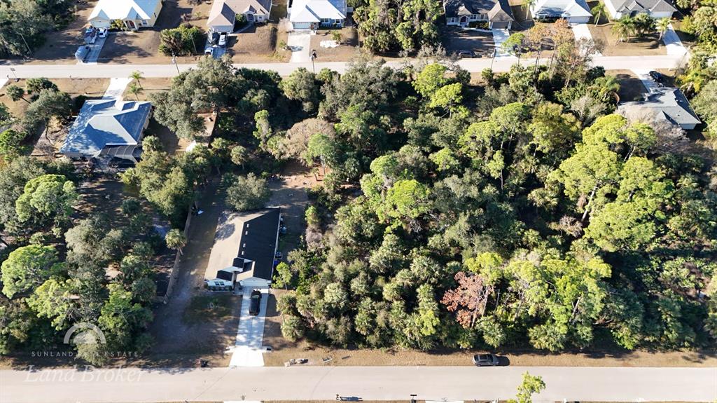 An aerial view shows a house with a driveway surrounded by dense trees and vegetation — SPARKLE LANE, NORTH PORT, FL