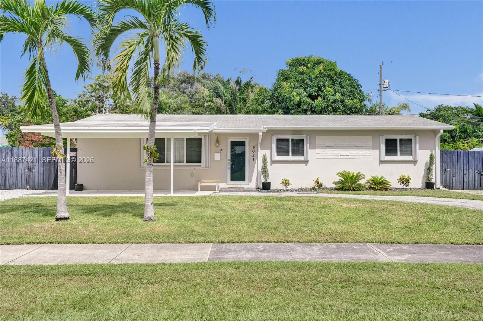 A single-story house with a carport, palm trees, and a front lawn under a blue sky — 9021 SW 197th St, Cutler Bay FL 33157, CUTLER BAY, FL
