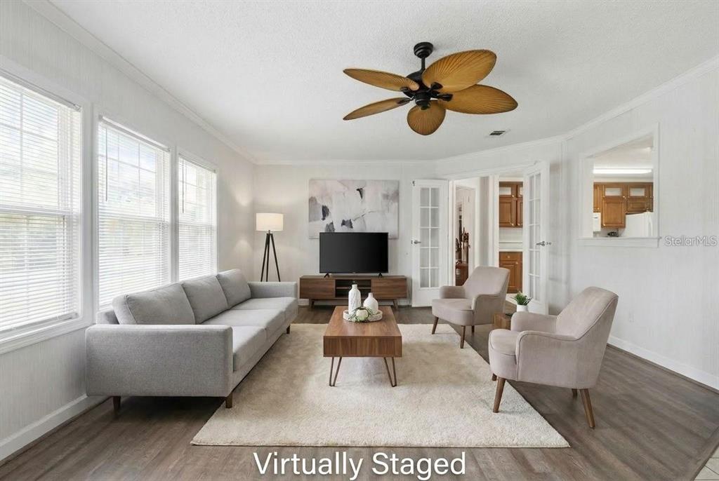 A virtually staged living room features a grey sofa, two armchairs, and a wood coffee table — 8798 SW 66TH AVENUE, OCALA, FL