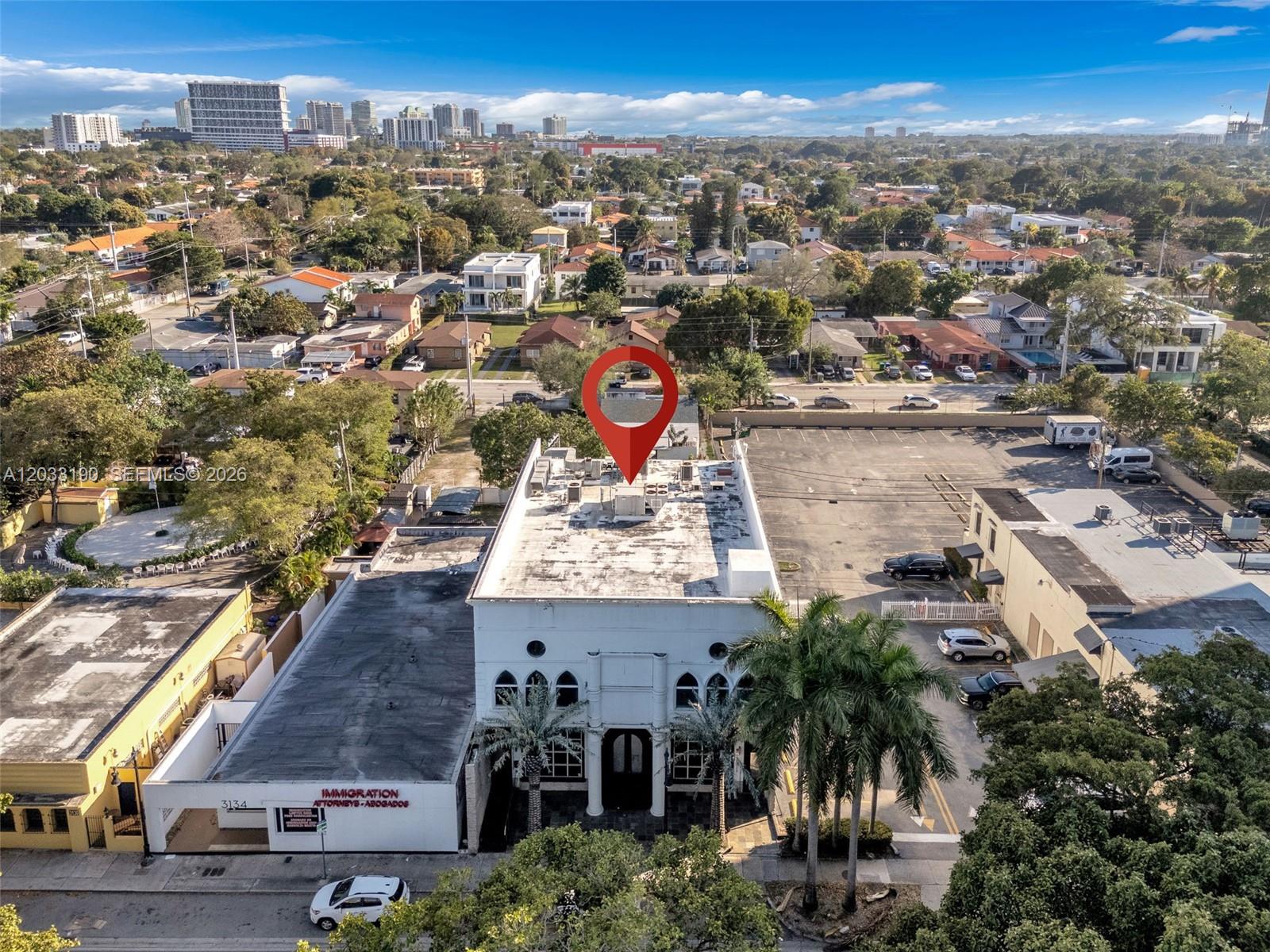 An aerial view shows a white commercial building with a parking lot and surrounding neighborhood — 3138 Coral Way, Miami FL 33145, MIAMI, FL