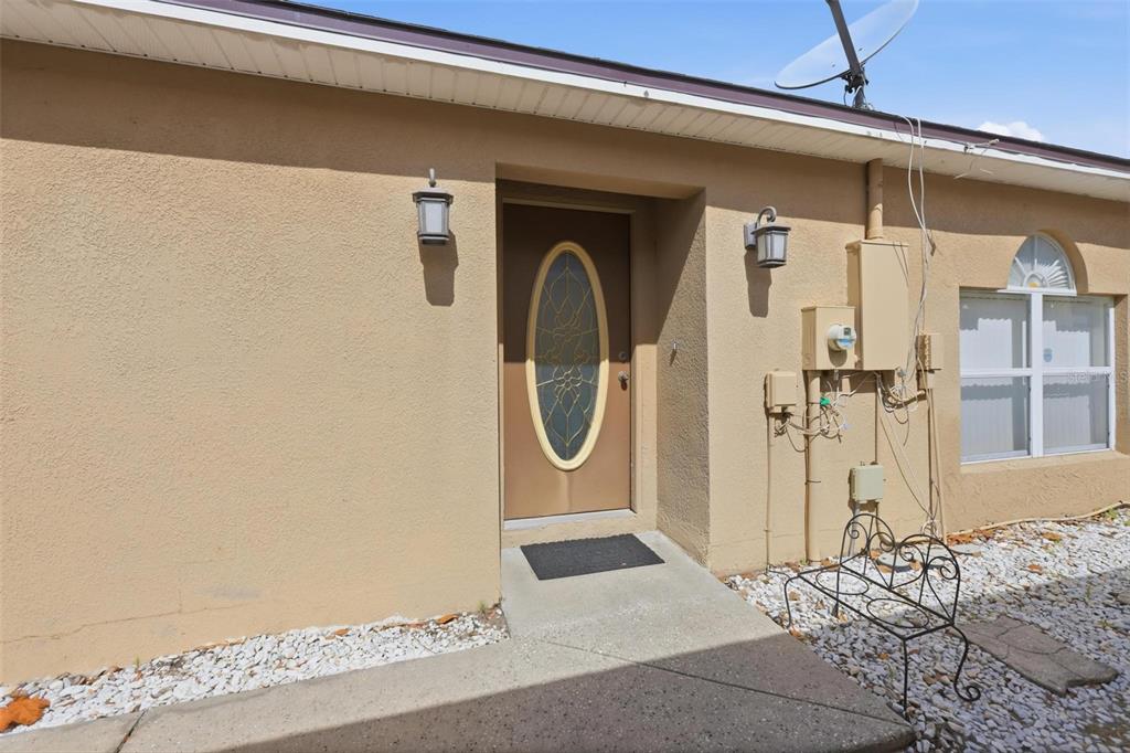 A tan, single-story house with a two-car garage and a cracked concrete driveway — 138 PLACID WOODS COURT, SANFORD, FL