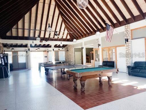 A large community room features a vaulted wood-beam ceiling, a pool table, and tiled flooring — 580 S JASMINE STREET, CLEWISTON, FL