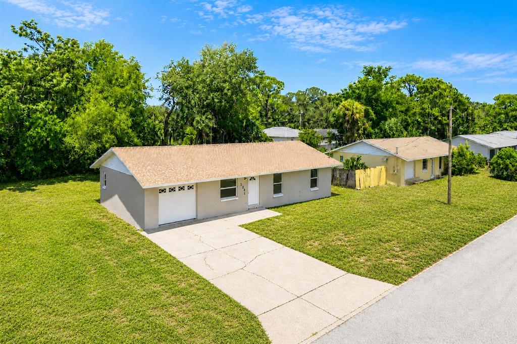 A single-story house with a tan roof, gray exterior, and a concrete driveway — 324 QUEEN AVENUE, OVIEDO, FL