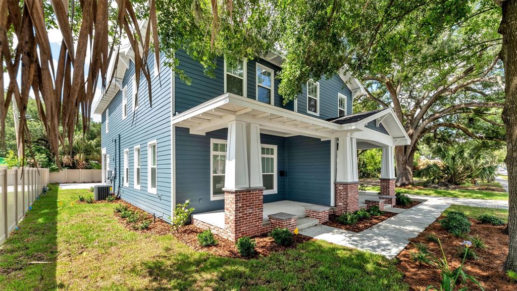 A two-story blue house with a brick-based front porch and a white fence — 1031 E LIME STREET, LAKELAND, FL
