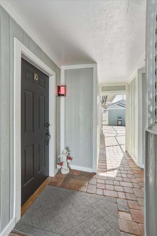 A dark front door with the number ten leads to a paved outdoor walkway — 13730 DOWNING LANE UNIT W-1, FORT MYERS, FL