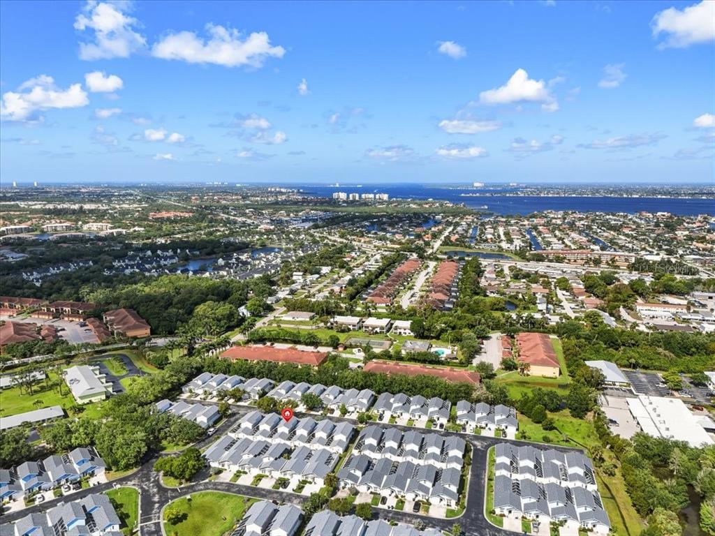 An aerial view shows a residential neighborhood with townhouses and surrounding green space — 13730 DOWNING LANE UNIT W-1, FORT MYERS, FL