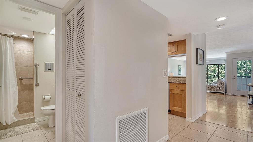 A view from a hallway looking into a bathroom, a kitchen, and a living area — 835 S OSPREY AVENUE UNIT 201, SARASOTA, FL