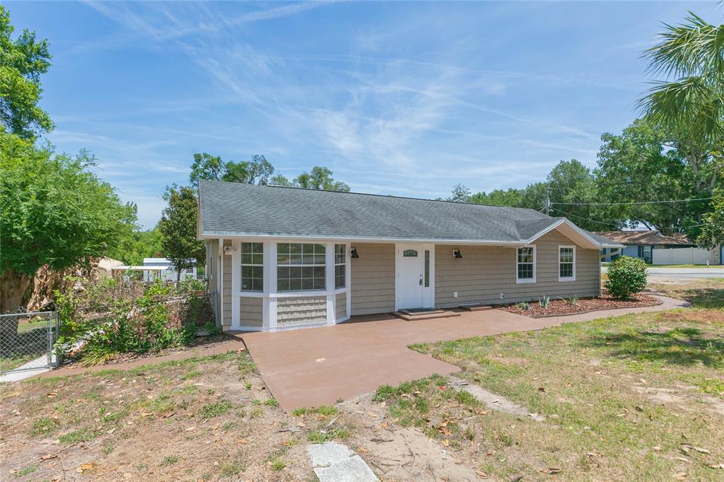 A single-story house with tan siding, a bay window, and a brown concrete patio — 13410 LEE STREET, DADE CITY, FL