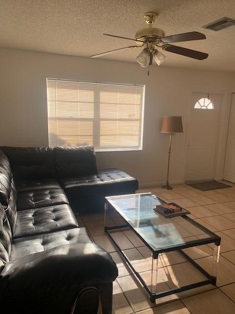 A living room features a black sectional sofa, glass coffee table, floor lamp, and ceiling fan — 933 Francis Street, West Palm Beach FL 33405, WEST PALM BEACH, FL
