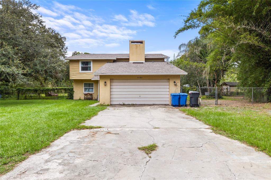 A two-story house with yellow siding, a concrete driveway, and a two-car garage — 5105 FIVE ACRE ROAD, PLANT CITY, FL