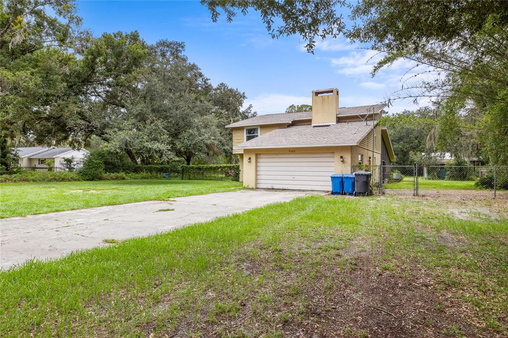 A two-story house with a beige exterior, a two-car garage, and a concrete driveway — 5105 FIVE ACRE ROAD, PLANT CITY, FL