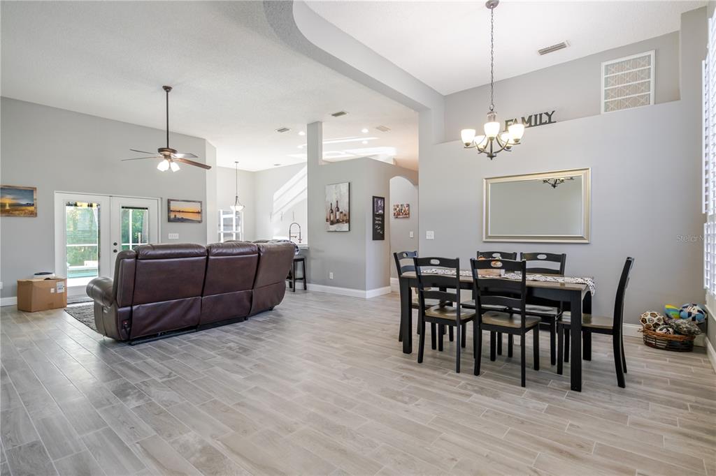 A dining area and living room with light gray tile flooring and neutral walls — 1001 ENGLISH BLUFFS COURT, BRANDON, FL