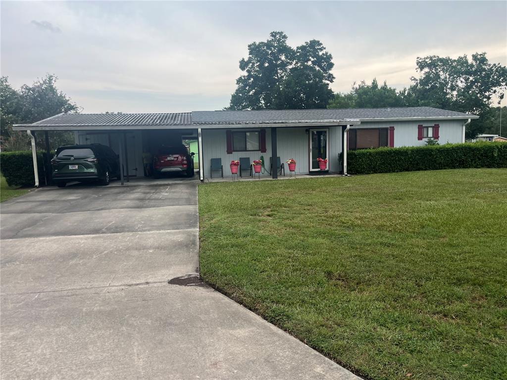 A single-story house with a metal roof, a carport, and a concrete driveway — 9090 SW 104TH PLACE, OCALA, FL