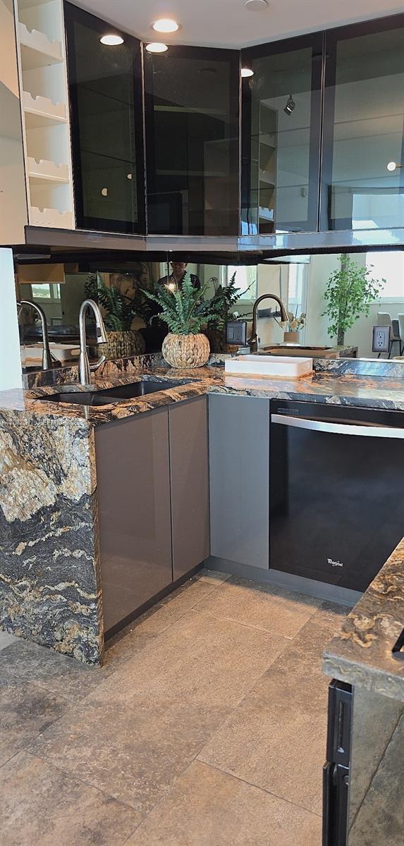 A kitchen corner features dark granite countertops, grey cabinets, a black dishwasher, and mirrored backsplash — 300 S Pointe Dr # 908, Miami Beach FL 33139, MIAMI BEACH, FL